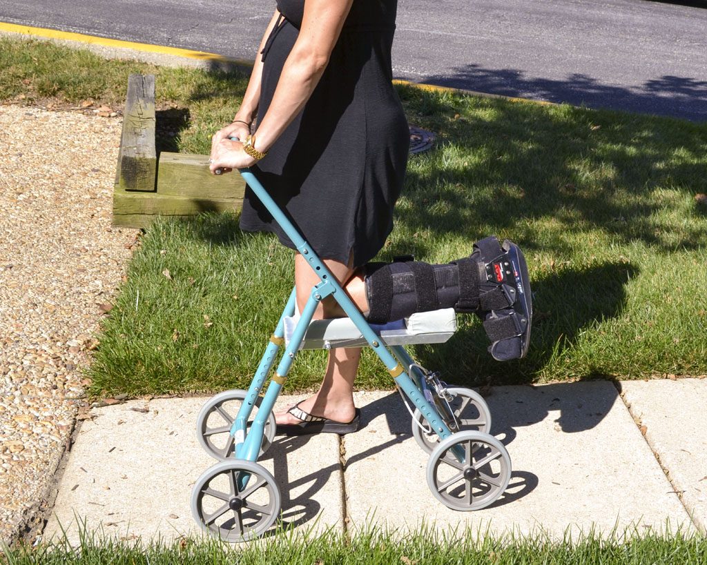 A woman using Standard knee walker